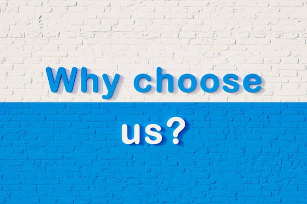 istock Why choose us? Colored capital letters against a white and blue brick wall. 1390093012