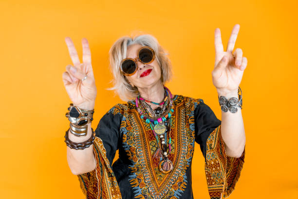 funny portrait of mature woman. beautiful lady have fun dressed with seventies costume - hippie imagens e fotografias de stock