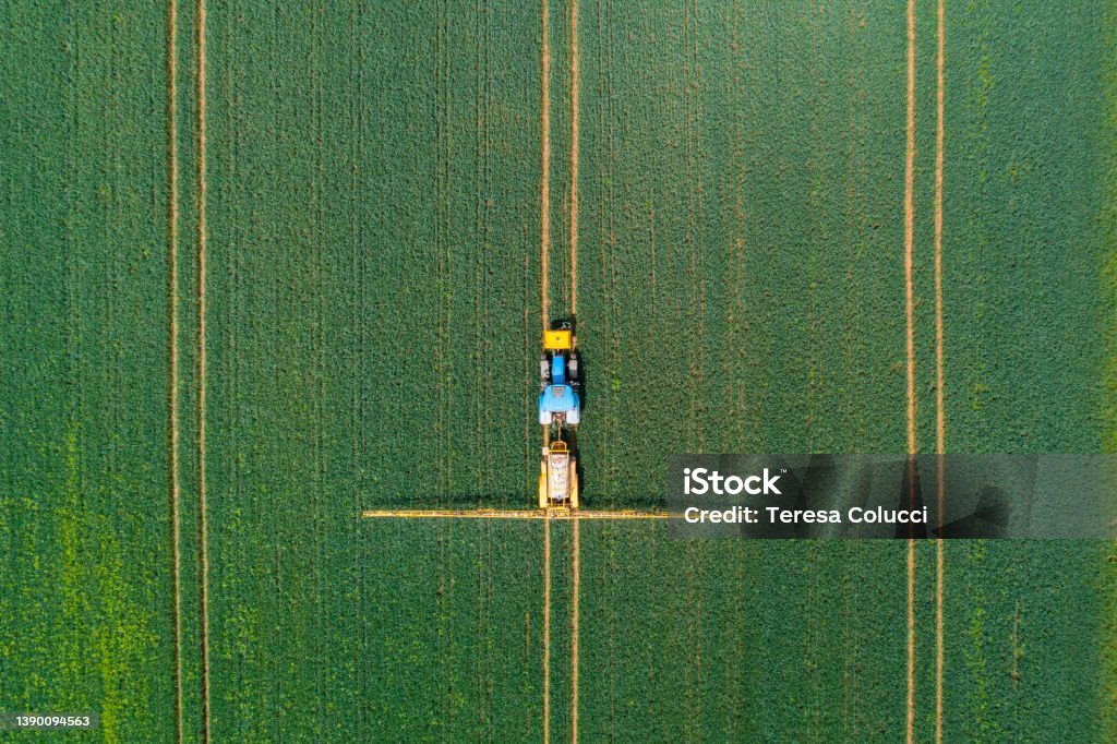 Aerial view of farming tractor crop sprayer in the countryside Corn Stock Photo