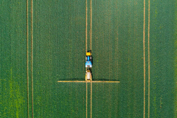 вид с воздуха на сельскохозяйственный тракторный опрыскиватель сельскохозяйственных культур в сельской местности - crop sprayer insecticide spraying agriculture стоковые фото и изображения