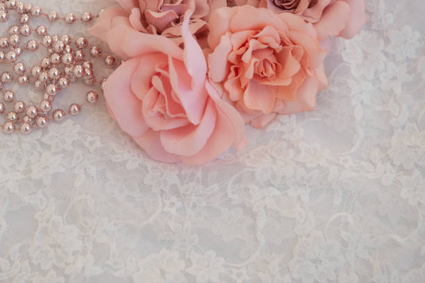 White lace with flowers and pink pearls for a romantic backgroud with empty space