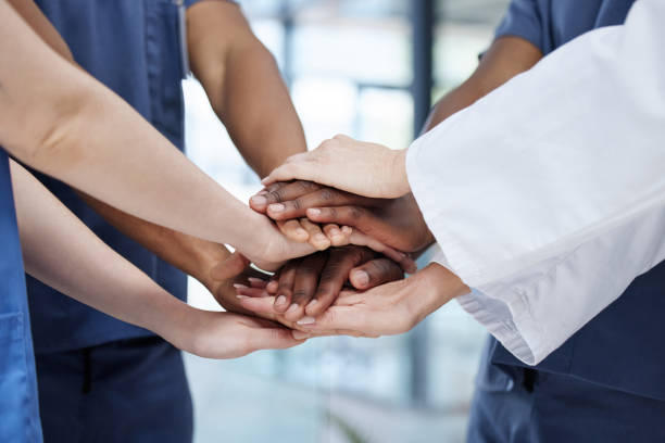 istock Shot of a group of unrecognizable doctors stacking their hands at work 1390096414