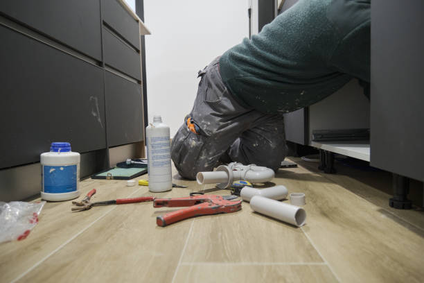 istock Mature plumber installing sink siphon in domestic kitchen. 1390096679