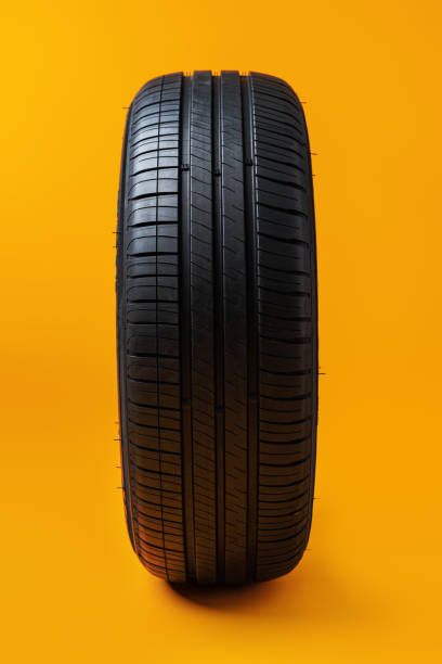 istock Car tires isolated on yellow background, close up 1390097827