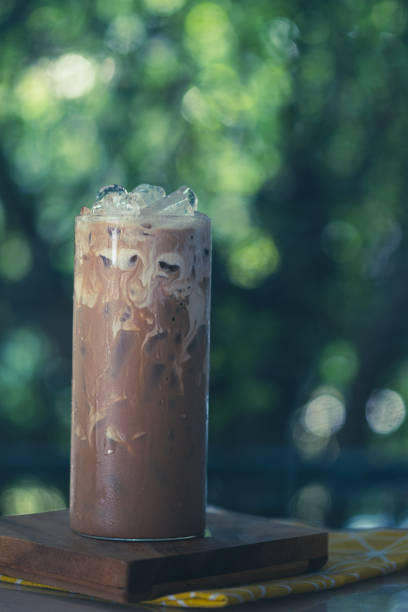 istock Ice coffee on a wood table with cream in tall glass. 1390097899