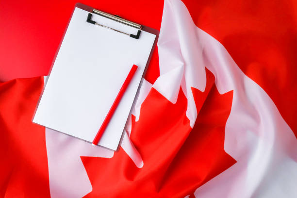 istock The National Flag of Canada. Canadian Flag or the Maple Leaf with empty paper note Copy space. Tourist traveler or patriotism. International relations concept. Independence day 1390098855