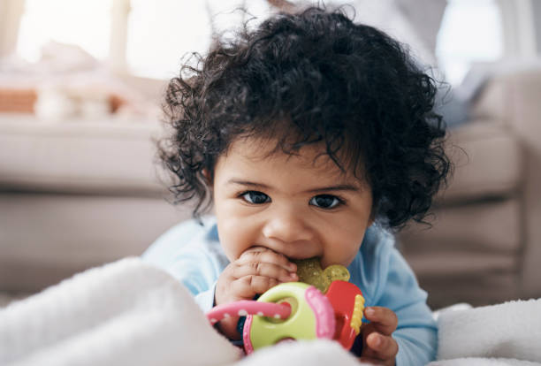 foto de una adorable niña tirada en el suelo de la sala de estar y jugando con un juguete - playing playful baby contemporary fotografías e imágenes de stock