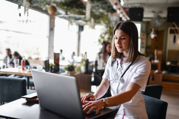 istock Cute Nurse Using Banking Software On Laptop While Relaxing In Bar 1390099478