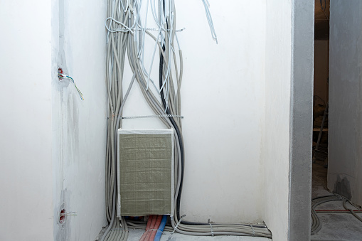 Electricity wiring. Plastic corrugated tubes and electrical wires during the installation of the switchboard.