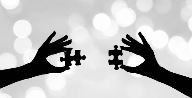 Two hands put two pieces of the puzzle together Two hands put two pieces of the puzzle together hände stock pictures, royalty-free photos & images
