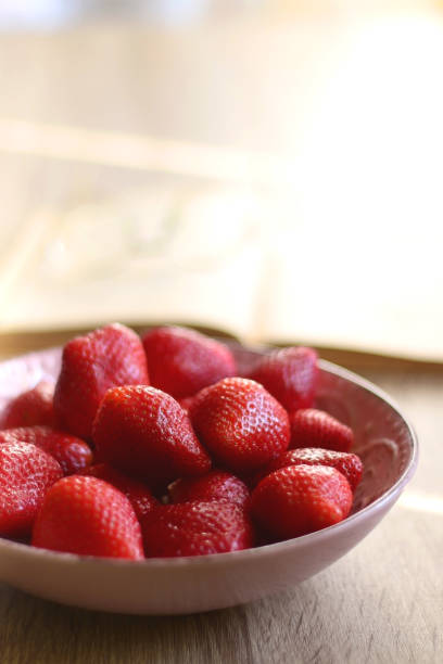 istock Bowl of Strawberries, Open Book and Reading Glasses 1390101836