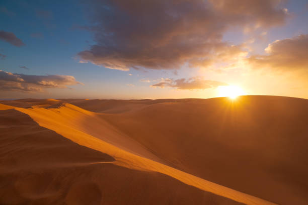 istock Golden sands. Sunset in Maspalomas desert. Sunset in the desert, Dramatic clouds, sun and sunrays. Gran Canaria, Canary islands, Spain 1390101889