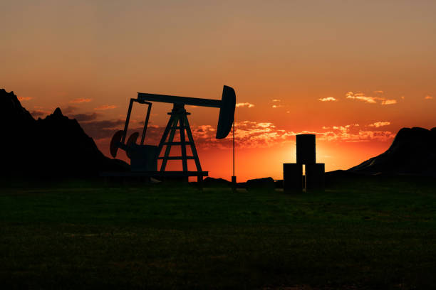 silhueta de uma bomba de óleo e barris de petróleo na estepe do deserto entre montanhas durante o pôr do sol. - oil rig sea oil well oil drill - fotografias e filmes do acervo