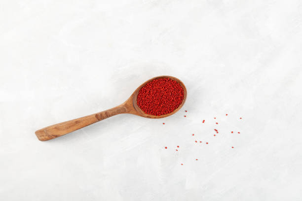 istock Organic beetroot couscous in wooden spoon on light grey surface, top view 1390103246