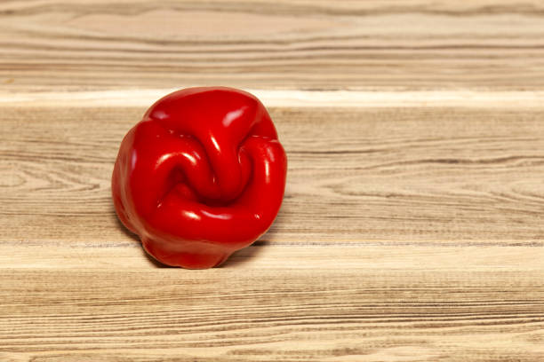 istock Ugly crooked red pepper on wooden background 1390103297
