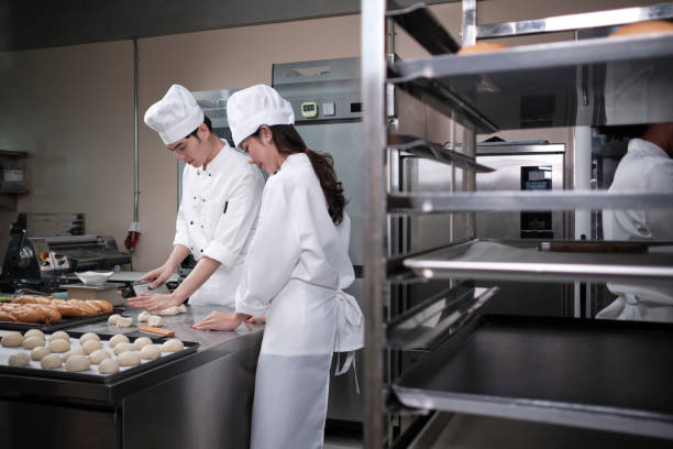 istock Two Asian chefs in uniforms prepare to bake bread and pastry in a kitchen. 1390104064