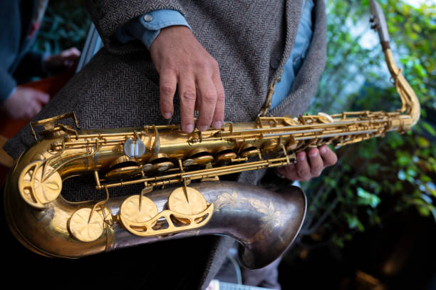 nahaufnahme eines saxophons. hände, die ein saxophon spielen. musikinstrumente - close up musical instrument saxophone jazz stock-fotos und bilder