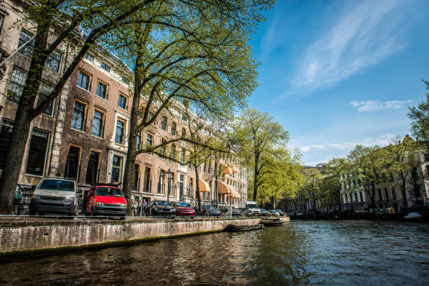 rio amstel com lados recheados por carros estacionados em amsterdã, holanda - amstel river - fotografias e filmes do acervo