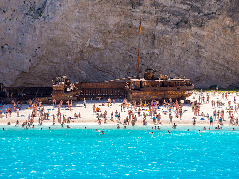 People swimming and taking photos on Navagio Shipwreck Beach, Zakynthos, Greece