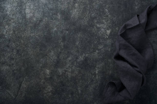 istock Linen kitchen brawn towel napkin on old black ceramic cement concrete table background. Cooking stone backdrop. Top view with copy space. Flat lay 1390105145