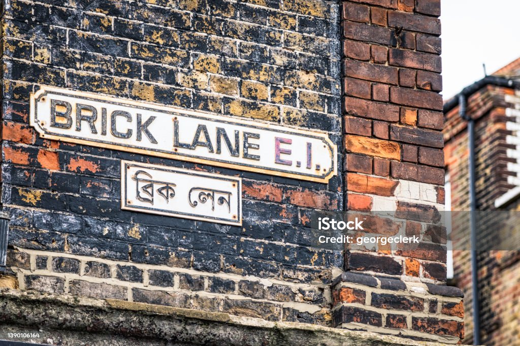 Brick Lane sign in East London A sign for Brick Lane, in both languages. The street is long and famous for its restaurants and traditional street markets. Brick Lane - Inner London Stock Photo