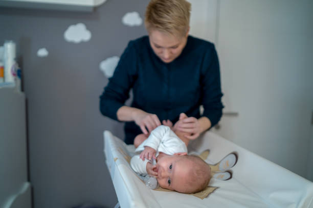 istock Female hands fixing a diaper on a newborn lying 1390106368