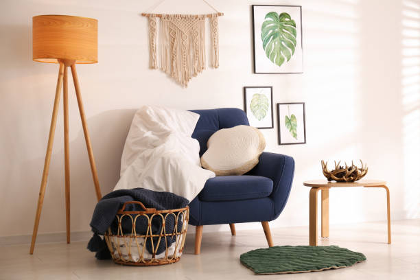istock Stylish room interior with comfortable armchair, blankets and beautiful decor elements 1390107243