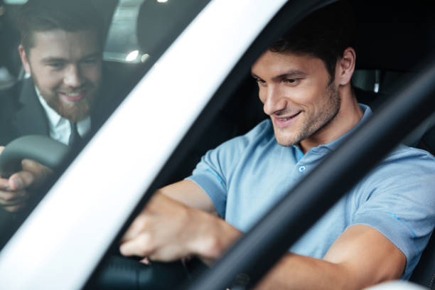 istock Young smiling couple testing a new car while sitting inside 1390107386