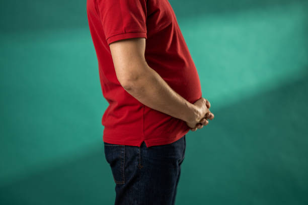 Man holding his big stomach stock photo