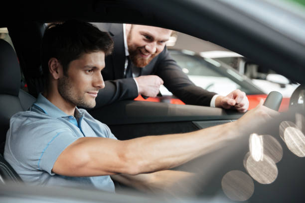 istock Young man testing a new car with a salesperson 1390108782