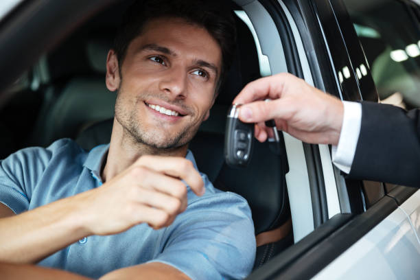 istock Smiling happy man sitting in his new car 1390108844