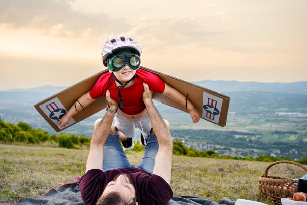 istock Father holding his son mid air pretending he is an airplane 1390109246