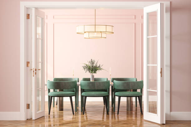 eingang des esszimmers mit esstisch, grünen samtstühlen und rosa wand im hintergrund - indoors color image photography nobody stock-fotos und bilder