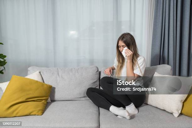Depressed Young Woman Covering Face By Hands Crying Alone At Home Upset Girl Sitting On Sofa Feeling Unhappy After Quarrel Or Breakup Despair And Lonely Psychological Problem Concept Stock Photo - Download Image Now