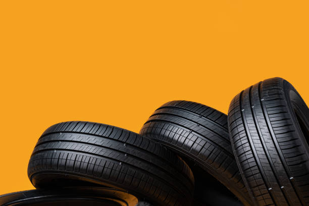 istock Car tires isolated on yellow background, close up 1390114432