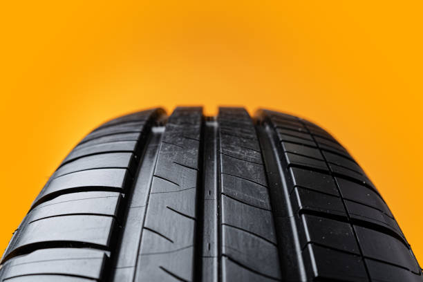 istock Car tires isolated on yellow background, close up 1390115725