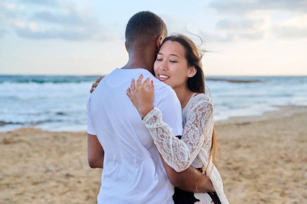 istock Young loving couple hugging on the beach 1390116661