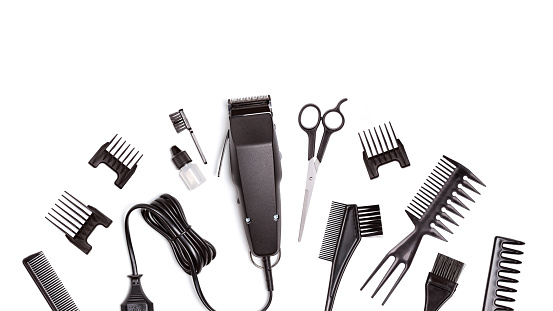 Professional hair clipper with set of nozzles of different sizes isolated on white background. Top view. Copy space for text