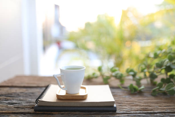 istock Small cup of coffee and notebooks and Peperomia Hope plant 1390119634