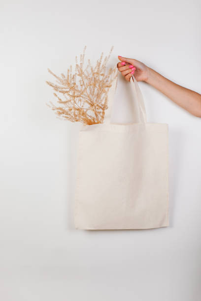 High quality premium canvas tote bag. Mockup White bag made on white isolated background with sprig of dried flowers for text or design, concept of zero waste