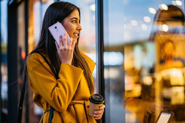 istock Woman talking on phone and window shopping 1390123136