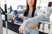 Sporty woman drinking energy drink in health club