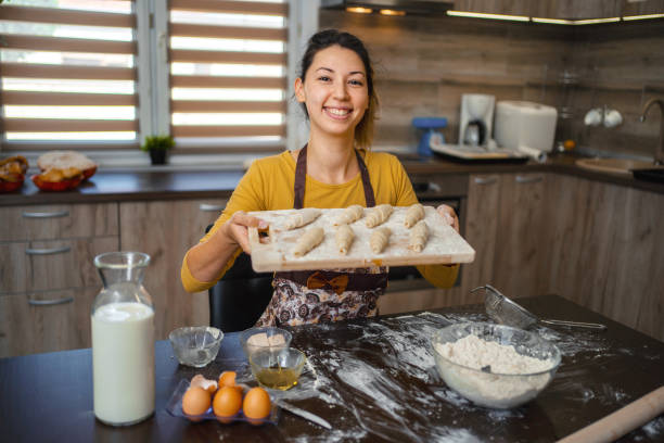 istock Young woman kneading fresh pastries in her home kitchen 1390130467