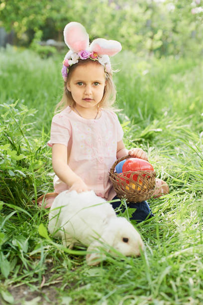 istock Baby with basket full of colorful eggs. Easter egg hunt. 1390130473