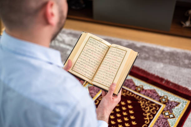 istock Muslim man reading quran on prayer mat 1390131202