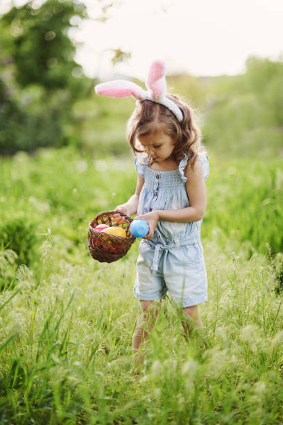 istock Baby with basket full of colorful eggs. Easter egg hunt. 1390131565
