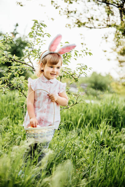 istock Baby with basket full of colorful eggs. Easter egg hunt. 1390131787