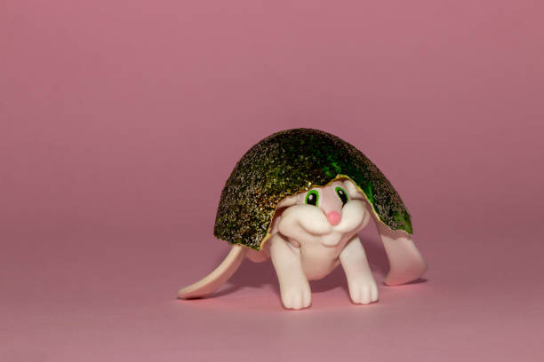 istock cute toy rabbit with a beautiful painted egg shell on her head, creative easter design with copy space 1390132389