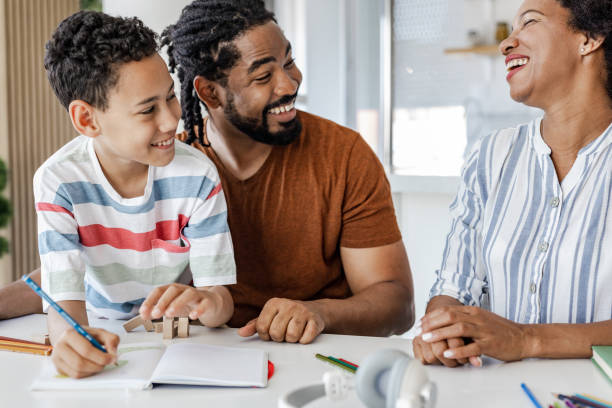 istock Cheerful parents helping their son with homework 1390132500