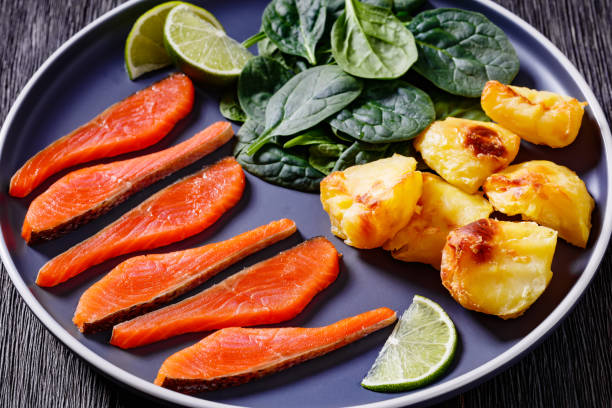 salmon slices with spinach leaves, roast potatoes - smoked salmon salt healthy lifestyle cold imagens e fotografias de stock